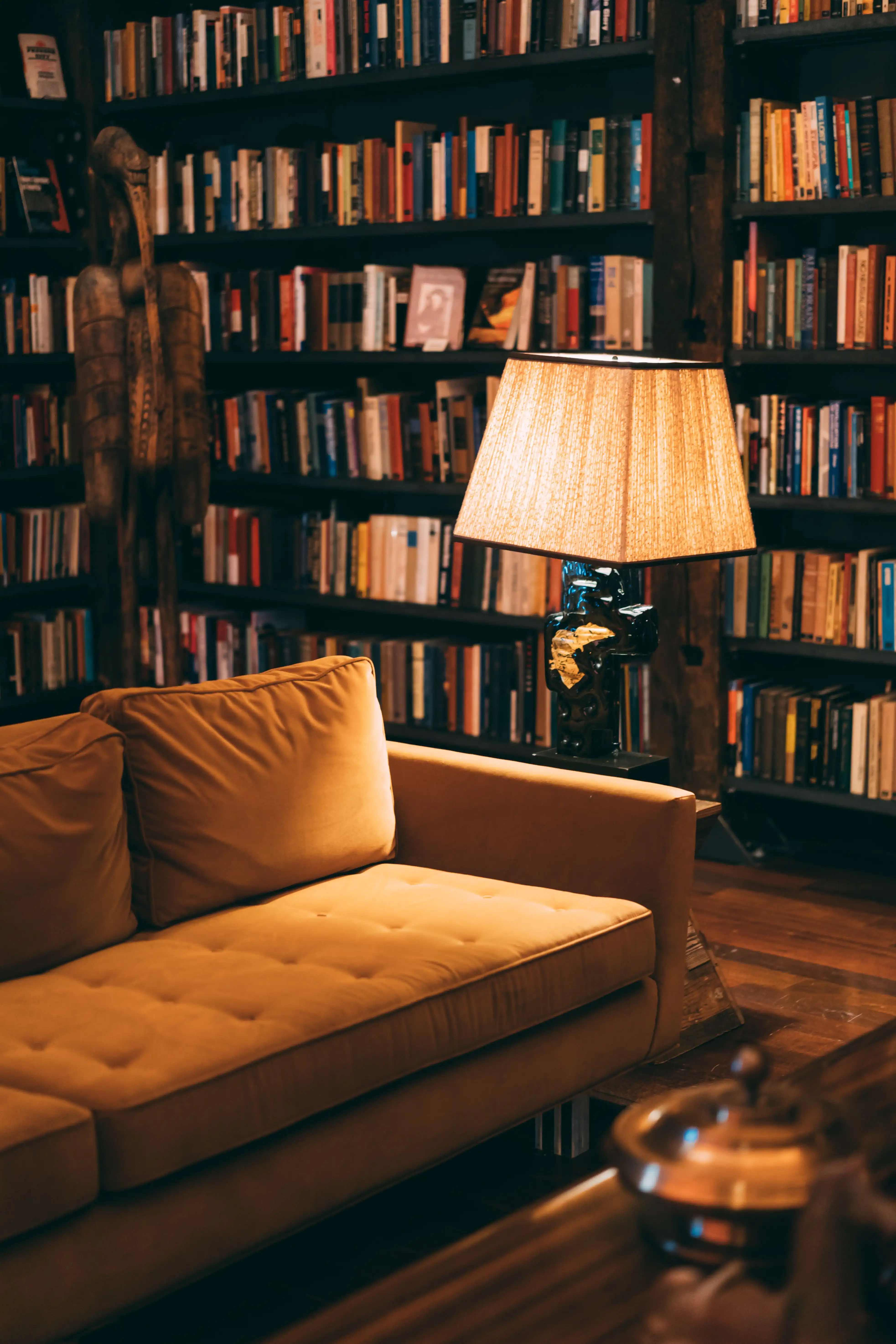 Floor-to-ceiling American black walnut library with brass rolling ladder